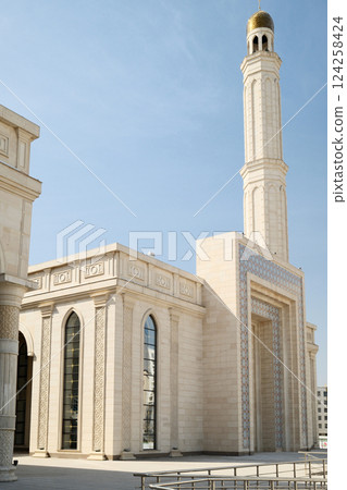 Elegant Minaret and Mosque Under a Blue Sky 124258424