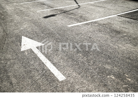 White painted arrow on asphalt surface White painted arrow on asphalt surface 124258435