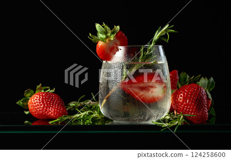 Hard seltzer with ice, strawberries, and rosemary. 124258600