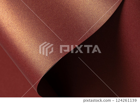 Burgundy paper background with a glossy, pearlescent texture and shimmering metallic finish. Rich 124261139