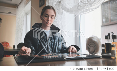 Customer seated at cafe table, scanning menu, contemplating lunch choices with relaxed demeanor in cozy dining environment 124261300