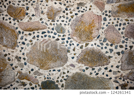 Weathered stone wall revealing traditional russian masonry, large rocks nestled among smaller stone fragments in rustic construction pattern Weathered stone wall revealing traditional russian masonry, large rocks nestled among smaller stone fragments in rustic construction pattern 124261341