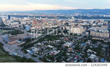 Aerial panorama revealing krasnoyarsk cityscape, spanning yenisei river, urban neighborhoods, industrial sectors, transportation networks beneath overcast skies Aerial panorama revealing krasnoyarsk cityscape, spanning yenisei river, urban neighborhoods, industrial sectors, transportation networks beneath overcast skies 124261448