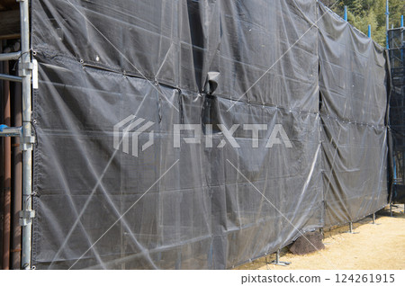 Scaffolding shielding sheet at a construction site Scaffolding shielding sheet at a construction site 124261915
