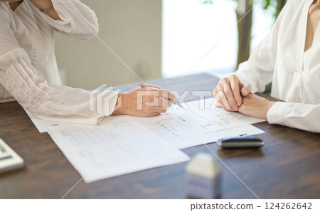 The hands of two women signing a real estate contract The hands of two women signing a real estate contract 124262642