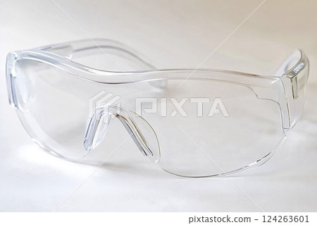 Transparent safety glasses resting on white surface providing eye protection 124263601