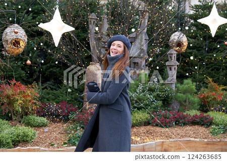 Joyful girl celebrating near Christmas tree decorations on Parisian street Joyful girl celebrating near Christmas tree decorations on Parisian street 124263685