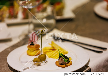 Elegant gourmet appetizers served on white porcelain. Elegant gourmet appetizers served on white porcelain. 124265790
