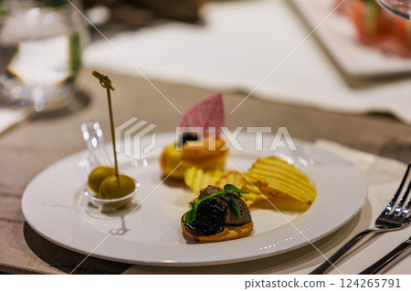 Elegant gourmet appetizers served on white porcelain. 124265791
