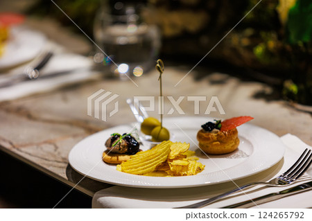 Elegant gourmet appetizers served on white porcelain. 124265792