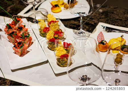 Elegant gourmet appetizer arrangement featuring salmon tartare cups, caviar bites Elegant gourmet appetizer arrangement featuring salmon tartare cups, caviar bites 124265803