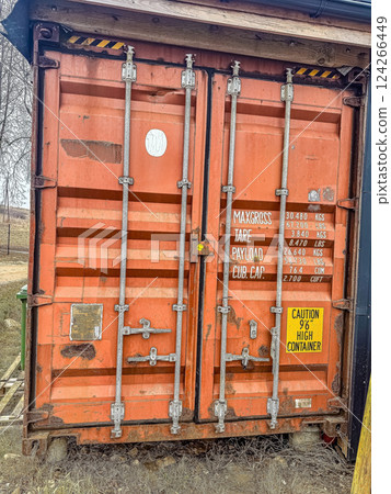 Orange shipping container with warning sign near rural area, showcasing cargo details and safety information on a clear day. High quality photo Orange shipping container with warning sign near rural area, showcasing cargo details and safety information on a clear day. High quality photo 124266449