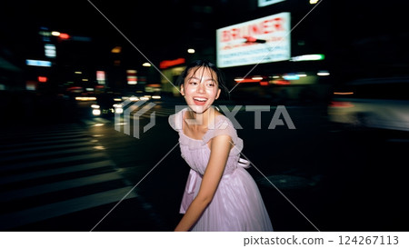 A flash-lit shot of a young woman wearing an elegant dress, in the middle of a busy city at night. Youth and happiness concept A flash-lit shot of a young woman wearing an elegant dress, in the middle of a busy city at night. Youth and happiness concept 124267113