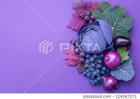 An artistic set of purple vegetables and fruits, including cabbage, eggplants, grapes, and onions, set against a vivid purple background. Perfect for concepts like color, health, organic food. 124267271