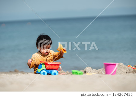 1 歲男孩在海灘玩沙子 124267435