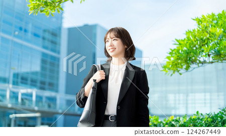 Smiling woman/businesswoman walking in an office district 124267449