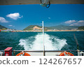 View of land from behind a ship sailing at sea 124267657