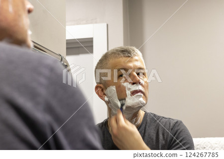 Reflection in the mirror of the man shaving Reflection in the mirror of the man shaving 124267785