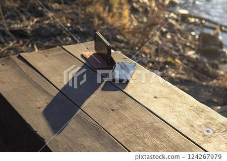 Shot of the two mobile phones on the wooden bench 124267979