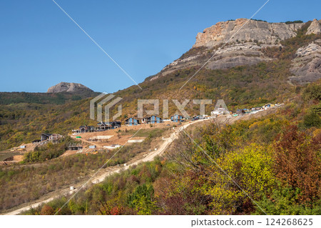 Construction of cottages under the mountain. Construction of cottages under the mountain. 124268625