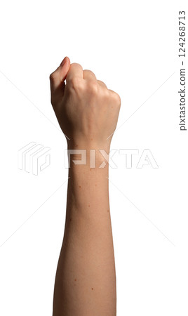 Female hand clenched into a fist, symbolizing strength, victory, and determination. Natural wrist 124268713