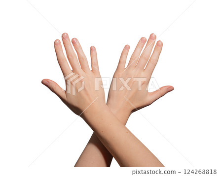 Well-groomed female hands with glossy, polished nails crossing at the wrist. Neat, soft skin with a 124268818