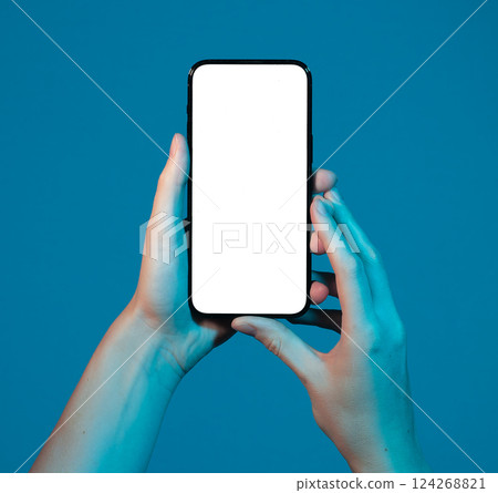 Smartphone held in both hands, blank screen for mockup. Woman presenting mobile device, modern tech Smartphone held in both hands, blank screen for mockup. Woman presenting mobile device, modern tech 124268821