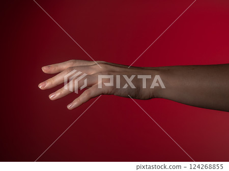 Hand reaching, fingers extended, gentle gesture. Woman's arm stretching, pinky out, soft motion in Hand reaching, fingers extended, gentle gesture. Woman's arm stretching, pinky out, soft motion in 124268855