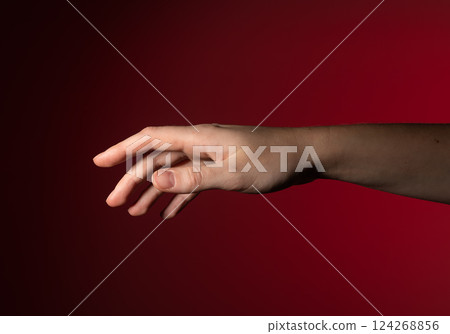 Hand reaching out, fingers gently stretching, pointing, showing subtle, graceful motion. Woman with 124268856