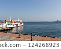 A view of the Seto Inland Sea and a ferry waiting to depart at the port [A ferry bound for Naoshima docked at Takamatsu Port] 124268923