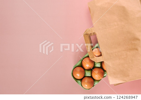 Kraft bag with chicken eggs in tray on beige background, shopping concept, space for text Kraft bag with chicken eggs in tray on beige background, shopping concept, space for text 124268947