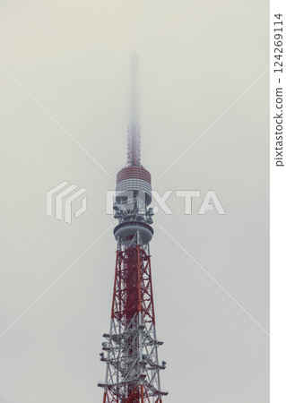 Tokyo Tower disappears into dense fog with its red and white steel frame softened by mist 124269114