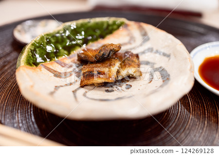 Grilled conger eel with a caramelized glaze served on a ceramic plate with soy Grilled conger eel with a caramelized glaze served on a ceramic plate with soy 124269128