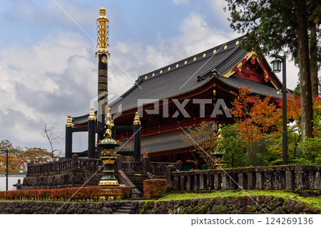 Goma-do Hall in Nikko Japan featuring a black and gold Buddhist monument in the foreground 124269136