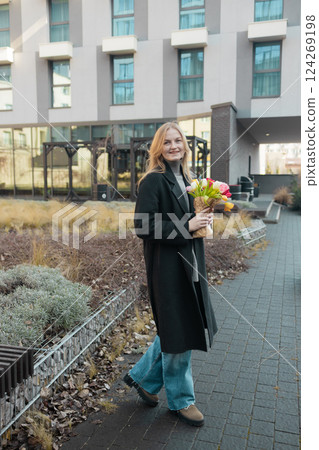 Happy International Women's Day Concept. Beautiful happy Caucasian woman smelling bunch of tulips with closed eyes 124269198