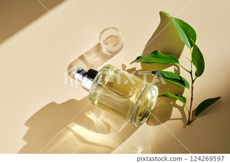 Perfume on a beige background in the rays of bright sun with beautiful highlights. Perfume on a beige background in the rays of bright sun with beautiful highlights. 124269597
