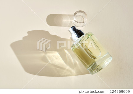 Perfume on a beige background in the rays of bright sun with beautiful highlights. Perfume on a beige background in the rays of bright sun with beautiful highlights. 124269609