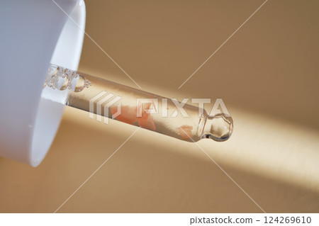 Pipette with serum on beige background with sunlight. 124269610