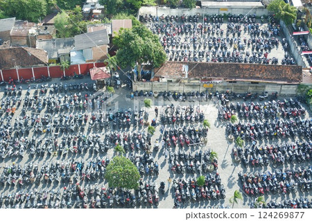 a densely packed motorcycle parking lot in an urban area 124269877