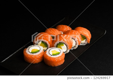 Delicious Fresh Salmon Sushi Rolls Presenting Exquisitely on a Black Background 124269917
