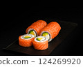 Delicious Fresh Salmon Sushi Rolls Presenting Exquisitely on a Black Background 124269920