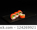 Delicious Fresh Salmon Sushi Rolls Presenting Exquisitely on a Black Background 124269921