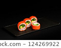 Delicious Fresh Salmon Sushi Rolls Presenting Exquisitely on a Black Background 124269922