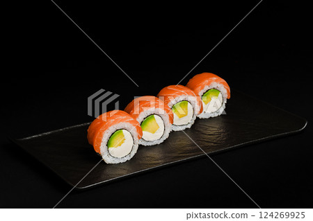 Delicious Fresh Salmon Sushi Rolls Presenting Exquisitely on a Black Background Delicious Fresh Salmon Sushi Rolls Presenting Exquisitely on a Black Background 124269925