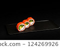 Delicious Fresh Salmon Sushi Rolls Presenting Exquisitely on a Black Background 124269926