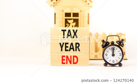 Tax year end symbol. Concept words Tax year end on beautiful wooden blocks. Beautiful white background. Black alarm clock. Business tax year end concept. Copy space. Tax year end symbol. Concept words Tax year end on beautiful wooden blocks. Beautiful white background. Black alarm clock. Business tax year end concept. Copy space. 124270140