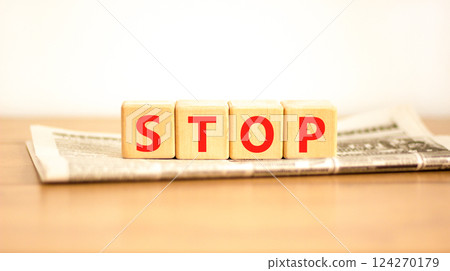 Stop symbol. Concept word Stop on beautiful wooden blocks on newspaper. Beautiful wooden table white background. Business, lifestyle, support and stop concept. Copy space. 124270179