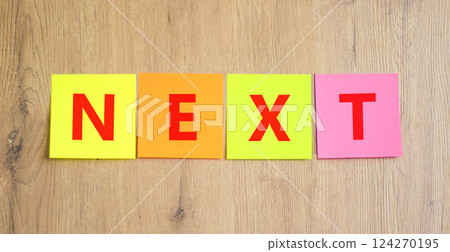 Next symbol. Concept word Next on beautiful colored paper. Beautiful wooden table wooden background. Business, lifestyle, support and next concept. Copy space. 124270195