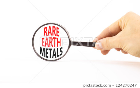 Rare earth metals symbol. Concept words Rare earth metals in beautiful magnifying glass. Beautiful white background. Businessman hand. Business and rare earth metals concept. Copy space. 124270247