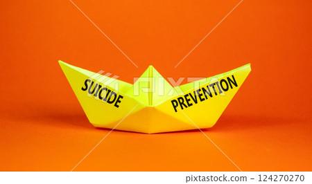 Suicide prevention symbol. Concept words Suicide prevention on beautiful yellow paper boat. Beautiful orange background. Psychological and suicide prevention concept. Copy space. Suicide prevention symbol. Concept words Suicide prevention on beautiful yellow paper boat. Beautiful orange background. Psychological and suicide prevention concept. Copy space. 124270270